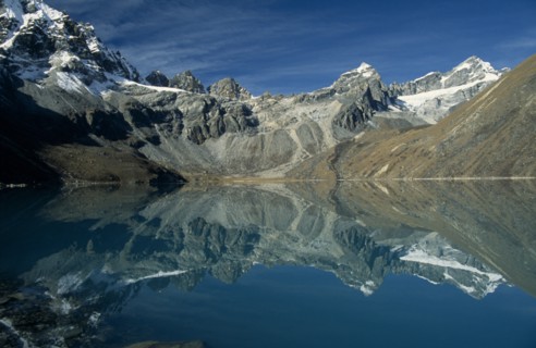 NEPAL, Everest Trek, Gokyo, View west over Dudh Pokhari Lake with snow capped mountains reflected