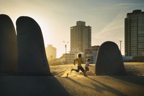 20091073 La Mano Sculpture hand beach Praya Brava  with children playing evening light. American Beaches Hispanic Immature Kids Latin America Latino Resort Sand Sandy Seaside Shore South America Touri...