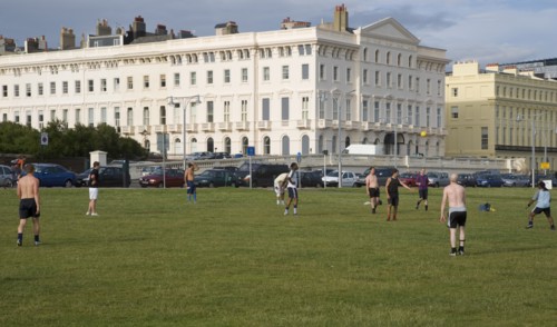 ENGLAND, East Sussex, Brighton, People playin football on hove seafront lawns.