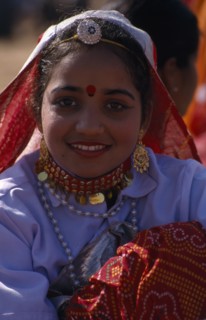 INDIA, Rajasthan, Jhunjhunu, Portrait of a young girl dancer smiling wearing traditional dress and
