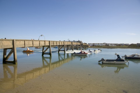 ENGLAND, West Sussex, Shoreham-by-Sea, Footbridge across the river Adur with waterskiers passing