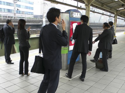 JAPAN, Honshu, Tokyo, "Yurakucho - the smokers corner on the JR train platform, men and young woman
