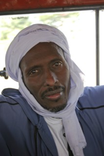 GAMBIA, Atlantic Coast, Banjul, Head and shoulders portrait of African Muslim man travelling on a