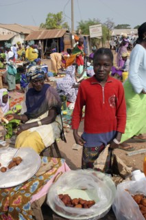 GAMBIA, Western Gambia, Tanji, Tanji market.  Young girl selling sweet snacks at Tanji market with