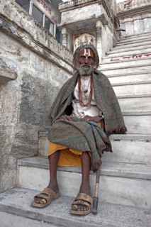 INDIA, Rajasthan, Udaipur, Elderly male Hindu beggar sitting on steps outside the Jagdish Temple