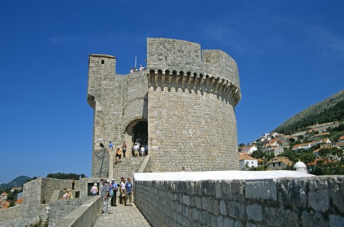 CROATIA, Dalmatian Coast, Dubrovnik, View along old city walls to Minceta Fort Tower and tourists.