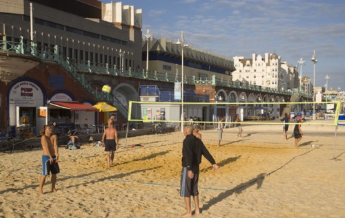 ENGLAND, East Sussex, Brighton, People playin beach volleyball on the seafront outside the Grand