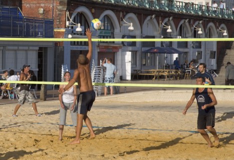 ENGLAND, East Sussex, Brighton, People playin beach volleyball on the seafront outside the Grand