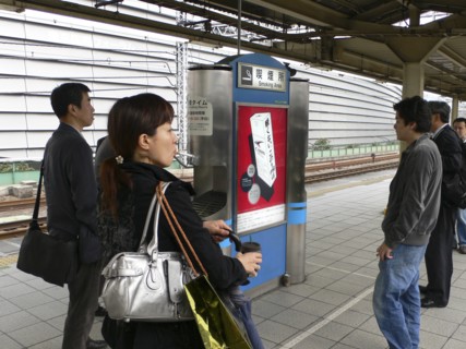 JAPAN, Honshu, Tokyo, "Yurakucho - the smokers spot on the train platform, men and a young woman