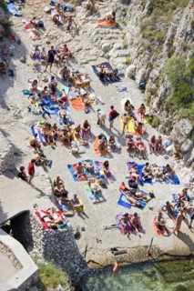 ITALY, Puglia, Lecce, Tricase.  Looking down on people sunbathing on coloured beach towels laid out