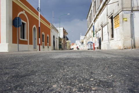 ITALY, South, Characteristic empty street lined with old coloured buildings.  Low angle shot from