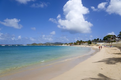 WEST INDIES, St Lucia, Gros Islet, Reduit Beach in Rodney Bay with tourists in the water and on the