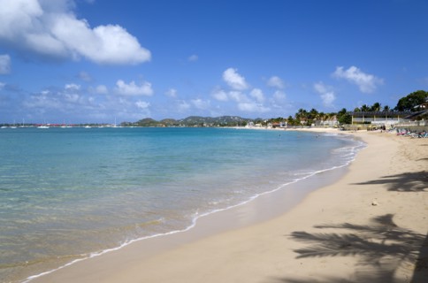 WEST INDIES, St Lucia, Gros Islet, Reduit Beach in Rodney Bay with tourists in the water and on the
