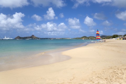 WEST INDIES, St Lucia, Gros Islet, Reduit Beach in Rodney Bay with tourists in the water and on the