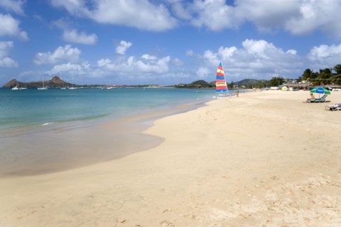 WEST INDIES, St Lucia, Gros Islet, Reduit Beach in Rodney Bay with tourists in the water and on the