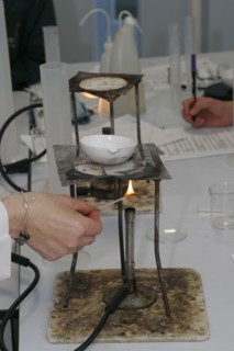 CHILDREN, Education, Secondary, Teacher lighting a bunsen burner prior to it being used for a food