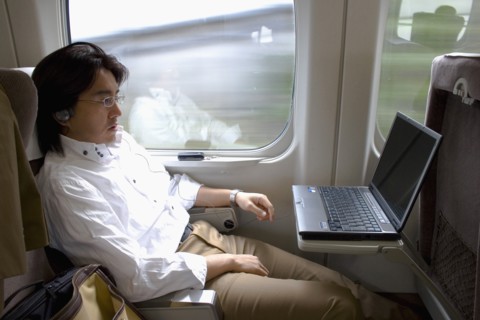 JAPAN, Honshu, Shinkansen train series 700 known as the ‘bullet train’.  Young Japanese man using