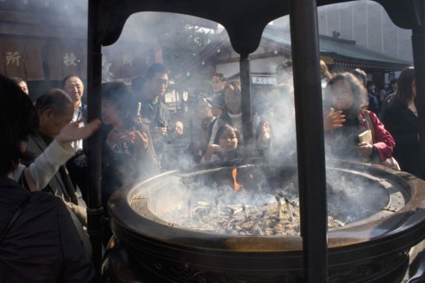 JAPAN, Honshu, Tokyo, Asakusa Kannon or Senso-ji Temple.  Japanese people wafting smoke from