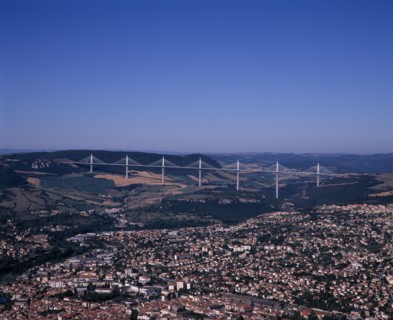FRANCE, Midi-Pyrenees, Aveyron, Millau.  Cityscape with Millau bridge beyond which carries the A75