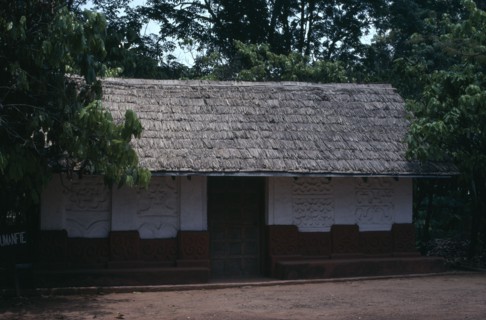 GHANA, Ashanti, Traditional thatched house with intricate patterns on walls.