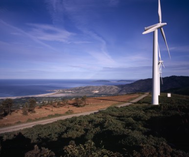 SPAIN, Galicia, Praia de Carnota, Coastal landscape with line of wind powered electricity