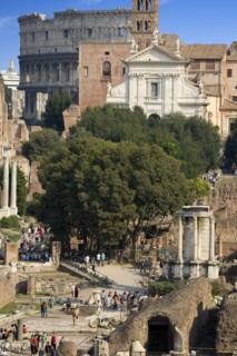 ITALY, Lazio, Rome, View of The Forum with the Colosseum rising behind the bell tower of the church