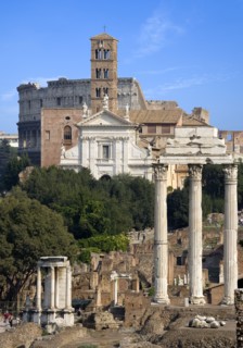 ITALY, Lazio, Rome, View of The Forum with the Colosseum rising behind the bell tower of the church