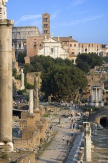 ITALY, Lazio, Rome, View of The Forum with the Colosseum rising behind the bell tower of the church
