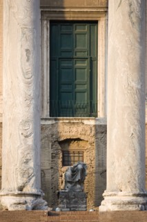 ITALY, Lazio, Rome, Broken seated statue between two columns at the entrance of the Temple of