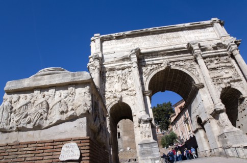 ITALY, Lazio, Rome, Tourists walking through the triumphal Arch of Septimius Severus in the Forum