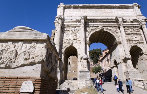 ITALY, Lazio, Rome, Tourists walking through the triumphal Arch of Septimius Severus in the Forum