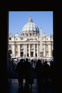 ITALY, Lazio, Rome, Vatican City Silhouette of tourists passing through an arch leading to the