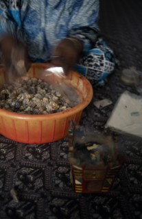 OMAN, Salalah, Trader bagging up frankincense for sale in souk.