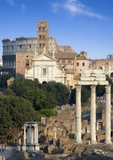 ITALY, Lazio, Rome, View of the Forum with the Colosseum rising behind the bell tower of the church