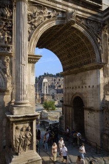 ITALY, Lazio, Rome, Tourists walking through the triumphal Arch of Septimius Severus with the three