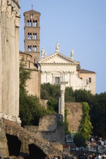 ITALY, Lazio, Rome, Tourists walking past the Temple of Antoninus and Faustina in the Forum with