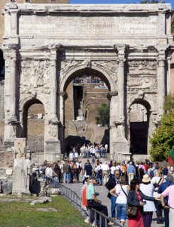 ITALY, Lazio, Rome, Tourists walking through the triumphal Arch of Septimius Severus from the Forum