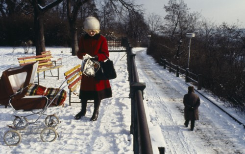 CZECH REPUBLIC, Prague, "Woman stopped to read newspaper in park in the snow.  She wears winter