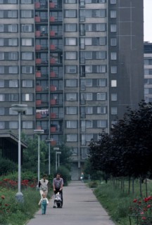 CZECH REPUBLIC, Prague, Multi-storey apartment block with young family walking along pathway in