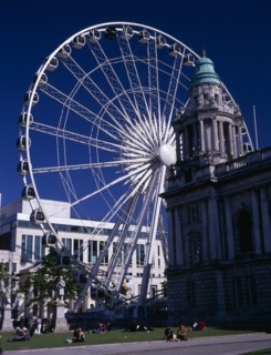 IRELAND, North, Belfast, People sitting or lying in the sun in the grounds of City Hall with The