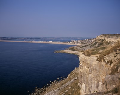 ENGLAND, Dorset, Portland, Chesil Beach viewed from quarried cliffs on north west of Isle of