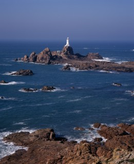 UNITED KINGDOM, Channel Islands, Jersey, St Brelade. Corbiere Lighthouse and rocky foreshore