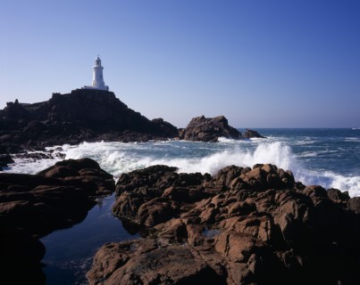 UNITED KINGDOM, Channel Islands, Jersey, St Brelade. Corbiere Lighthouse with waves crashing