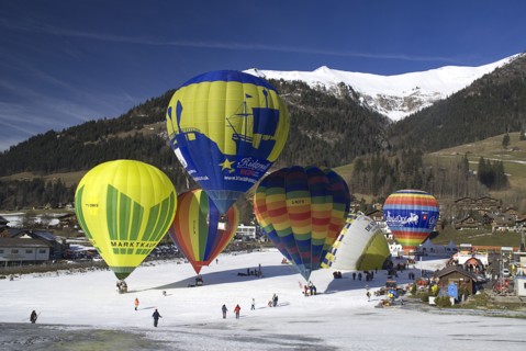 SWITZERLAND, Canton de Vaud, Chateau d'Oex, Hot Air Balloon taking off with others in preparation.