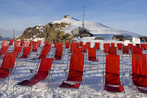 SWITZERLAND, Bernese Oberland, Mannlichen, Deckchairs on Mannlichen Mountain with cable car station