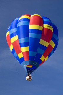 SWITZERLAND, Canton de Vaud, Chateau d'Oex, Single colourful Hot Air Balloon as it ascends after