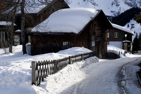 SWITZERLAND, Bernese Oberland, Murren, Snow covered house in the centre of Murren town.