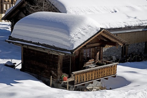SWITZERLAND, Bernese Oberland, Murren, Snow covered house in the centre of Murren town.