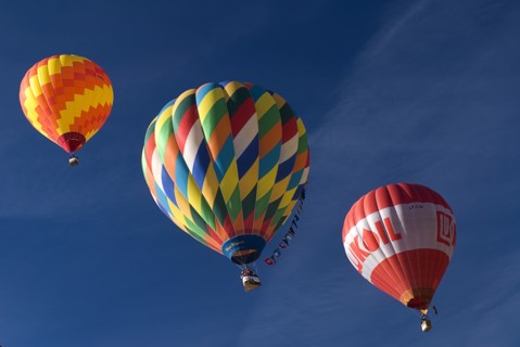 SWITZERLAND, Canton de Vaud, Chateau d'Oex, Three Hot Air Balloons in line ascending into a blue