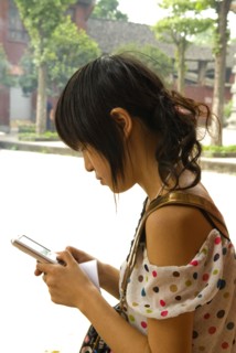 CHINA, Sichuan Province, Chongqing, "Girl using a mobile phone, a local tour guide at the 1500 year
